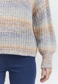 Strickpullover in creme-, orange- und hellblauen Farbtönen. Mit gerippten Bündchen und Saum, lockerer Passform und strukturiertem Design.