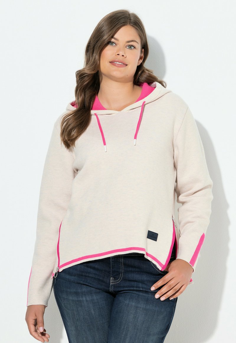 Pull en laine à capuche beige clair avec des accents et des détails en hem rose vif. Présente une fermeture éclair sur le côté, des manches longues et une coupe décontractée.