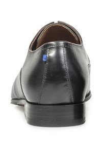 Scarpa da uomo in pelle nera, texture liscia, tacco arrotondato, interno marrone, accento blu sul tacco, dettagli cuciti lungo le cuciture.