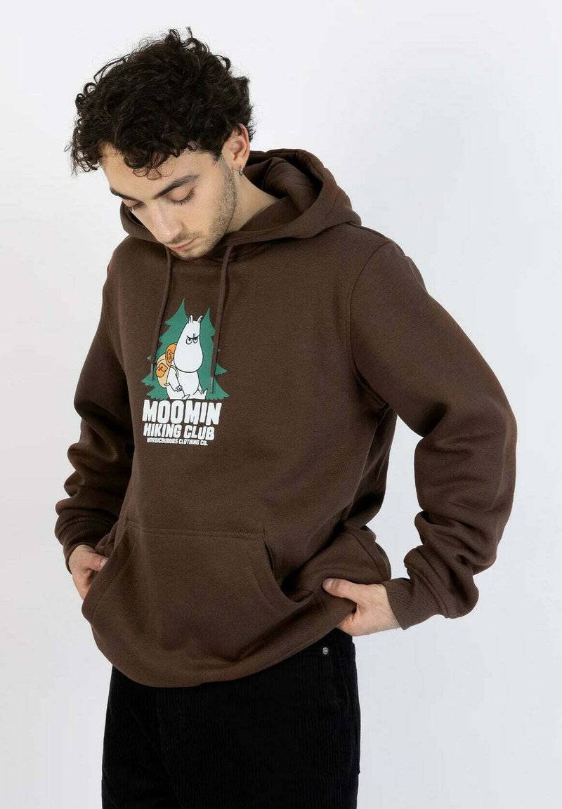 Ruskea huppari, jossa on Muumi-hahmon kuvio ja teksti "MOOMIN HIKING CLUB." Siinä on kengurutasku ja kiristysnyörillä varustettu huppu.