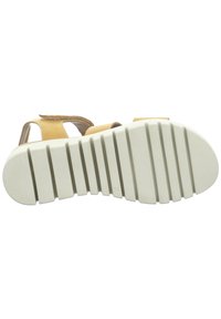 Yellow sandal with brown accents, closed toe design, adjustable strap, textured white sole with multiple grooves, flat profile.
