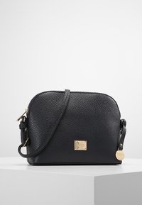 Borsa a tracolla in pelle nera con una texture a pallini, hardware in tonalità oro e una placca rettangolare con logo. Dotata di una tracolla regolabile.