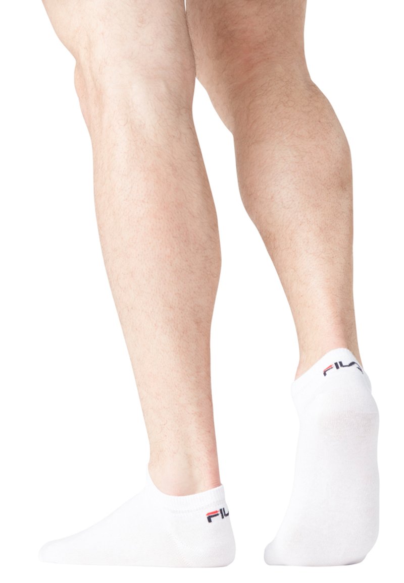 Chaussettes blanches à la cheville en mélange de coton, dotées d'un bord côtelé et d'un logo rouge et noir sur le talon. Texture douce, design minimaliste.