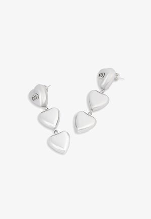 Hõbedased südamekujulised kõrvarõngad, mis on kaunistatud kolme omavahel seotud südamega, kõrge läikega viimistlus ja kinnituvad postikinnitusega.