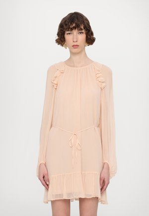 Robe légère couleur pêche avec des accents en volants, manches longues, taille à nouer et un ourlet en volants superposés. Texture douce.