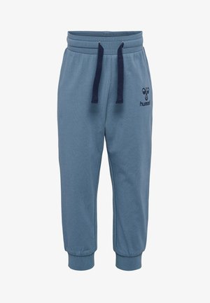 Niebieskie dresy wykonane z gładkiego materiału, z elastycznym pasem ze sznurkiem i ściągaczami na nogawkach. Logo Hummel na lewym nogawce.