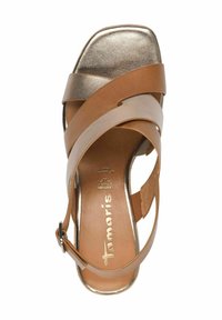 Brun och metallisk öppen tå sandal med korsade remmar, justerbar ankle strap och vadderad fotbädd. Har en fyrkantig klack och slät yta.