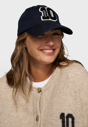 Cappellino da baseball in cotone di colore blu navy con logo ricamato "10" bianco e nero sul davanti. Presenta una visiera curvata e una chiusura regolabile.