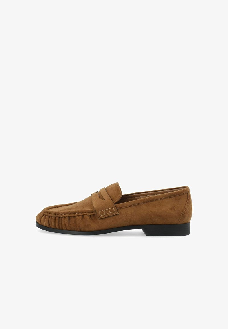 Mocassin en daim marron avec semelle noire, surpiqûres décoratives et détail de sangle sur le dessus, vu de profil.