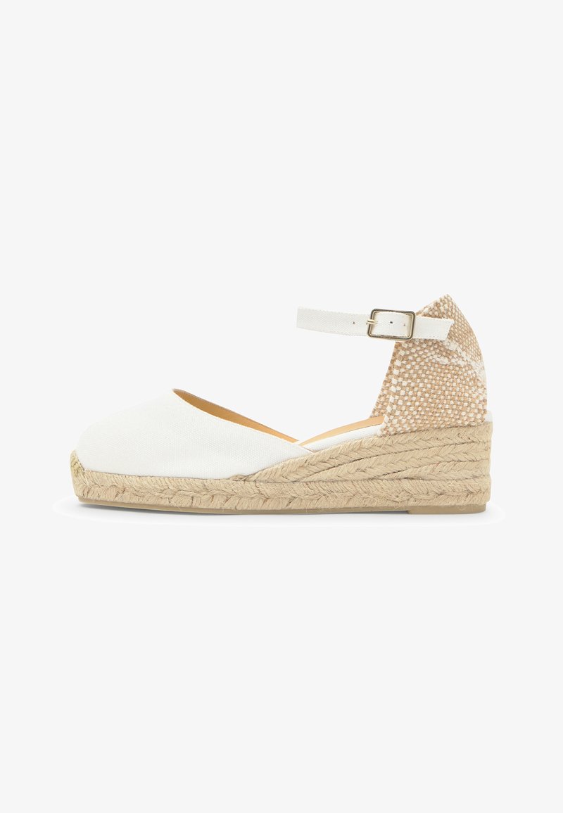 Espadrille blanche à talon compensé avec semelle en jute, bride cheville avec boucle, et contrefort talon tissé beige.