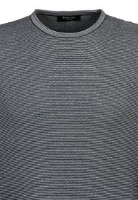 Graues gestricktes T-Shirt mit kurzen Ärmeln und runder Ausschnitt, das ein strukturiertes Muster und subtile horizontale Streifen aufweist. Markenetikett am Hals sichtbar.