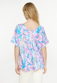 Kortärmad blus i ett lätt tyg, med V-rygg, flerfärgad abstrakt blommönster i rosa, blå och gröna nyanser.