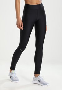 Czarne legginsy sportowe z elastycznego materiału z wysokim stanem i bocznymi szwami. Posiadają małe logo na dolnej części nogi.