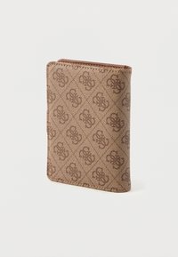 Hnědá texturovaná peněženka stojící vzpřímeně s opakovaným tmavě hnědým proplétaným monogramem na světlém pozadí.