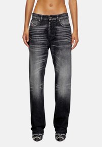 Zwarte denim jeans met een rechte snit, voorzien van een vervaagde wassing, zakken aan de voorkant en een knoopsluiting. Kenmerkende stiksels op de tailleband.