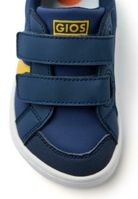 Sneaker blu navy con due cinturini in Velcro, logo giallo, pelle liscia, dettagli testurizzati e suola in gomma bianca.