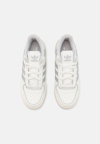 Vita lädersneakers med grå detaljer, med tre ränder och perforerade detaljer på tån. Snören och vadderad tunga ingår.