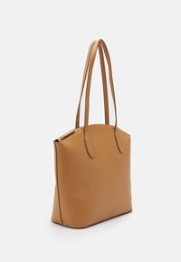 Sac fourre-tout en cuir fauve avec deux longues anses, texture lisse, haut arrondi et fermeture éclair. Bords renforcés et design minimaliste.