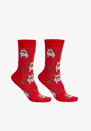 Rote Baumwollsocken mit cartoonartigen Motiven von einem Hund und Lebkuchenfiguren in einem wiederholenden Muster. Weiche Textur, mittellang bis zur Wade.
