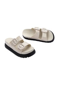 Białe plastikowe klapki plażowe z dwoma regulowanymi paskami, wyposażone w kwadratowe klamry, profilowaną wkładkę i grubą czarną gumową podeszwę.