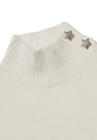 Maglione bianco lavorato a maglia con collo alto a costine e due decorazioni a forma di stella argentata sulla cucitura della spalla. Tessuto morbido.