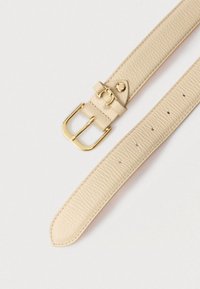 Ζώνη από μπεζ δέρμα με υφή, με αγκράφα από μεταλλικό υλικό σε χρυσή απόχρωση και πέντε τρύπες για ρύθμιση μεγέθους.