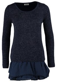 Dlouhý rukáv top s tmavě modrým pleteným vrškem a volánkovou spodní vrstvou s puntíky. Měkká textura a pohodlný design. Kulatý výstřih.