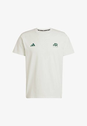 Witte katoenen T-shirt met korte mouwen, voorzien van een groen Adidas-logo en tekst op de linkerkant van de borst en een groen driehoeklogo op de rechterschouder.
