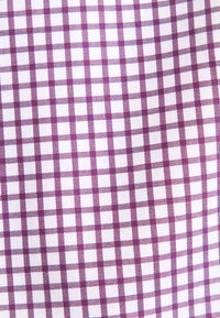 Katoenen stof met een paars en witte geblokte patroon. De vierkanten zijn gelijkmatig van grootte, met een gestructureerde afwerking en contrasterende kleuraccenten.