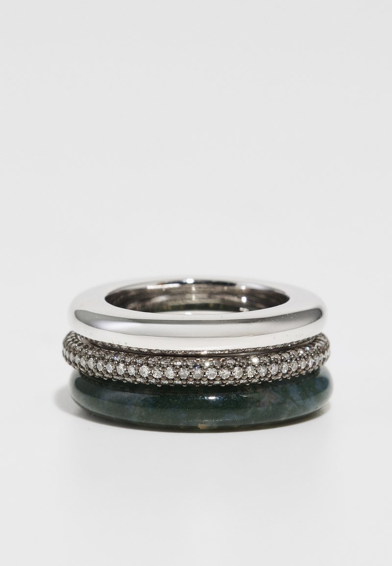 Anillo apilado que presenta una banda de plata pulida, una banda con piedra verde y una banda engastada con diamantes con un intrincado detallado.