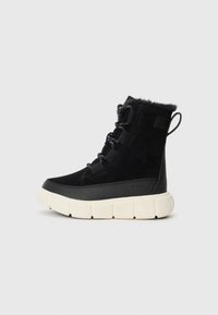 Botte de cheville noire imperméable avec une tige en suede texturée, doublure en fausse fourrure, bout rond, lacets renforcés et semelle en caoutchouc beige épaisse.