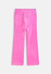 Helle pinke Velours-Loungehose mit elastischem Bund und "Juicy"-Text in Strasssteinen auf der Rückseite.