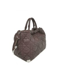 Borsa a tracolla marrone trapuntata con motivo a cuore, forma arrotondata e texture in morbida pelle. Presenta due manici corti e un portachiavi decorativo.
