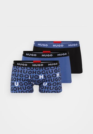 Three pairs of boxer briefs featuring elastic waistbands. Designs include logos in varying colors: a blue and black pair with repeated text.