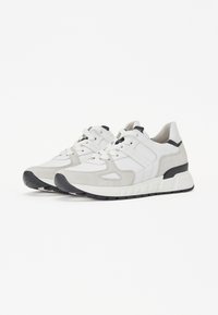 Jasnoszare sneakersy wykonane z połączenia teksturowanej zamszowej skóry i gładkiego materiału. Posiadają czarne akcenty, białą podeszwę oraz wyściełany język.