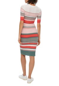 Robe en tricot avec des rayures horizontales en rose, rouge et vert. Manches courtes, coupe ajustée et texture côtelée avec un ourlet au niveau des genoux.
