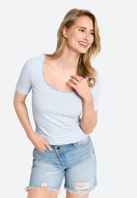 Gestreiftes kurzärmliges Oberteil in Blau und Weiß mit rundem Ausschnitt, kombiniert mit heller, distressed Jeansshorts.