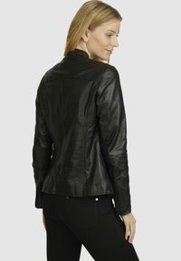 Black leather jacket with a fitted design, zippered cuffs, and back seams. Smooth texture and minimal stitching detail.