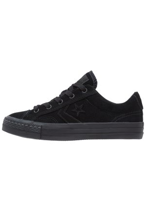 Niski czarny zamszowy sneaker z czarną gumową podeszwą, sznurówkami i logo gwiazdy po boku, pokazany z zewnętrznej strony.