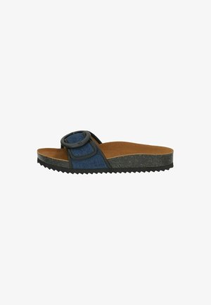 Sandalia deslizante de denim que presenta una gran hebilla circular negra, plantilla acolchada marrón y suela de goma negra texturizada con patrón en zigzag.