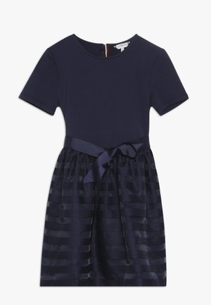 Robe bleu marine à manches courtes avec corsage ajusté, jupe en tulle rayé et ruban assorti noué à la taille.