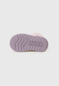 Fioletowa podeszwa sneakersa z falistym bieżnikiem i logo PUMA umieszczonym na białym tle.