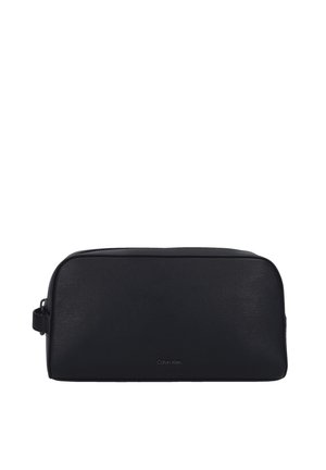Trousse de toilette en cuir noir avec une forme rectangulaire, une surface texturée, une fermeture éclair sur le dessus et une poignée latérale. Marquée du logo "Calvin Klein".
