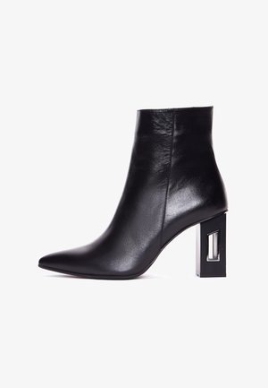 Schwarze Leder-Ankle-Boots mit spitz zulaufender Zehenpartie und einem einzigartigen rechteckigen Blockabsatz mit transparentem Akzent. Glatte Textur und elegantes Design.