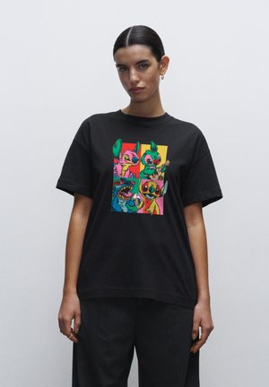 Black cotton t-shirt featuring a colorful printed graphic of cartoon characters on the front. Relaxed fit with short sleeves and a crew neck.