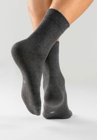 Graue Baumwollsocken mit geripptem Bündchen, weicher Textur und subtilen Mustern auf der Sohle. Das Design betont Komfort und Schlichtheit.