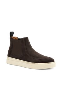 Stivaletti in suede marrone alla caviglia con pannelli elastici laterali, design affusolato e suole in gomma beige. Presentano una linguetta nera sul retro.