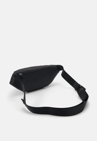 Juodas nailoninis fanny packas su užtrauktuku, stilingas dizainas, plokščias forma, reguliuojama dirželis ir lygus matinio paviršiaus tekstūra.