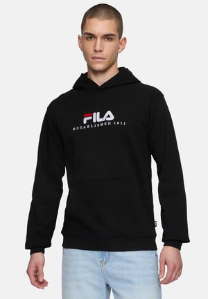 Svart hoodie av bomull med framficka och ribbade ärmslut. Har broderad "FILA"-logotyp i röd och vit. Avslappnad passform.