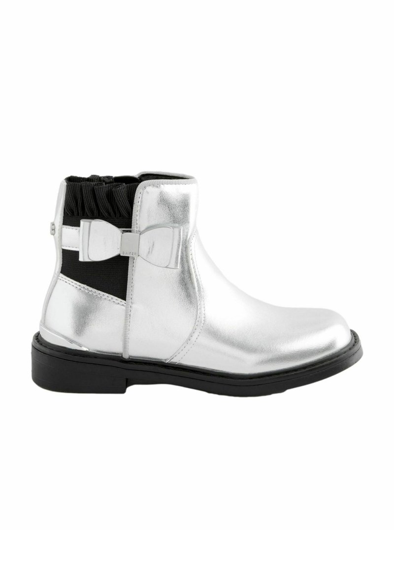 Botines metálicos plateados con punta redonda, lados elásticos y un lazo negro como acento. Presenta un collar texturizado y una suela plana negra.